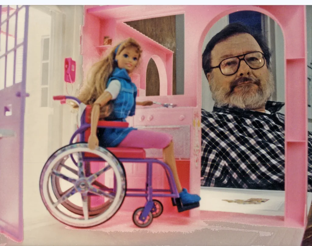 Ronald Mace vu à travers la porte de la maison de Barbie